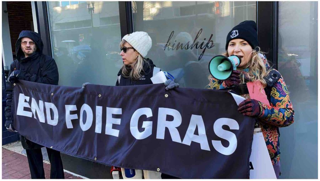 Photo of animal rights activists holding banner that says End Foie Gras